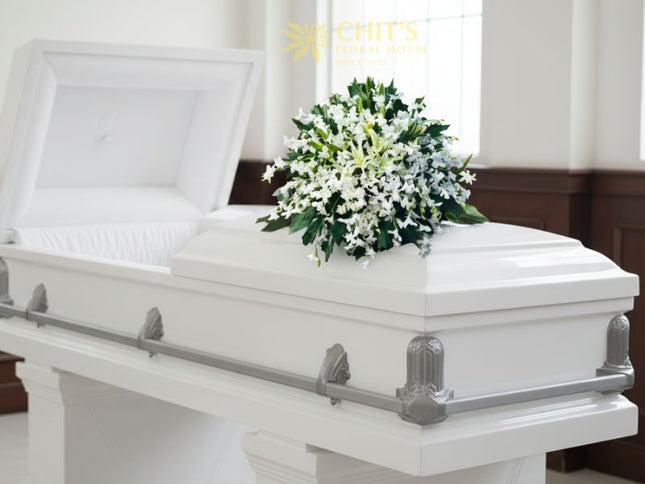Elegant funeral casket flower arrangement featuring pure white orchids symbolizing peace, remembrance, and eternal love. Handcrafted by Chits Floral House.