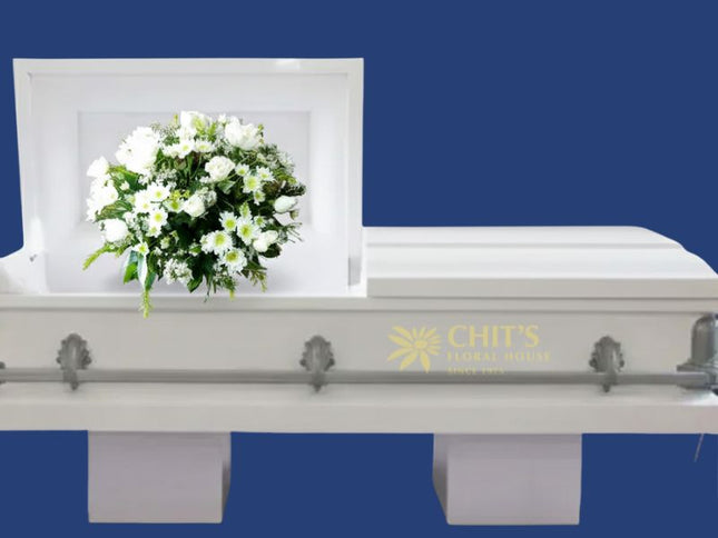 Elegant white casket flower arrangement featuring roses, chrysanthemums, and baby’s breath symbolizing peace and eternal rest.