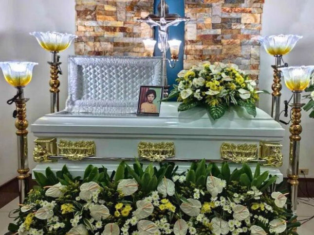 Beautiful funeral casket flower arrangement featuring white anthuriums and yellow chrysanthemums, handcrafted by Chits Floral House for memorial services.