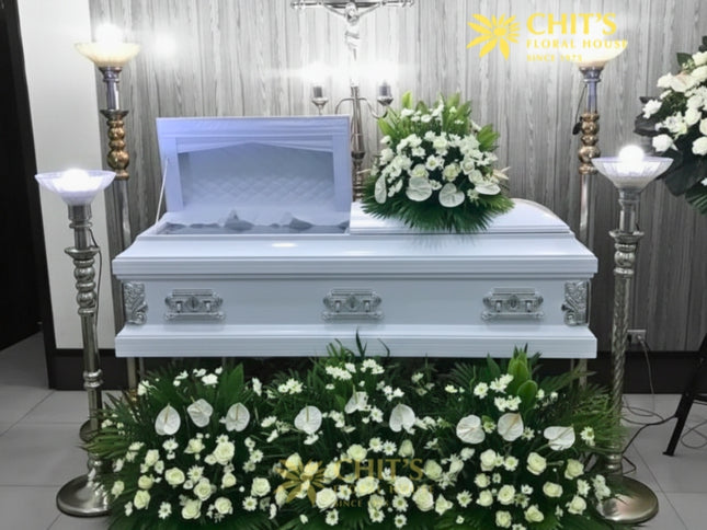 Classic white remembrance casket flower package with white roses, mums, and anthuriums