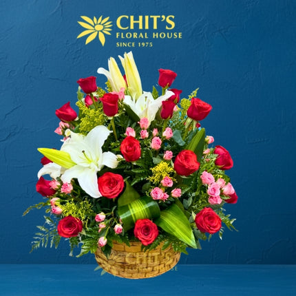 Large Undas floral spray with red roses, white lilies, miniature pink roses and yellow fillers in a basket