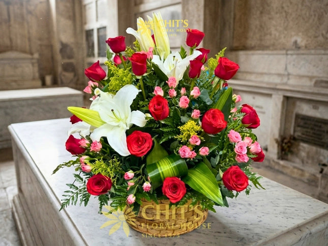 Large Undas floral spray with red roses, white lilies, miniature pink roses and yellow fillers in a basket
