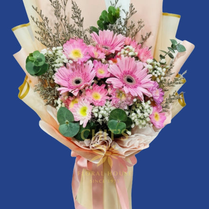 Freshly arranged gerbera daisies with imported fillers in pink tones