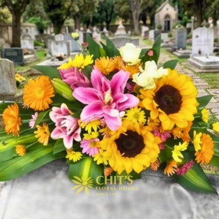 Sunflower and Pink Lily Memorial Lawn Floral Spray