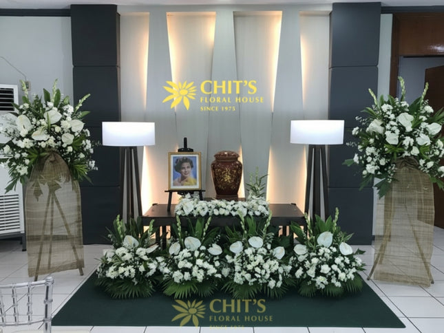 Urn funeral floral setup with white mums and anthuriums