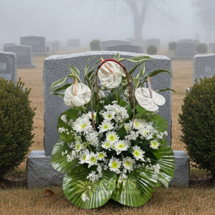 Close-up of white anthurium and lily condolence arrangement