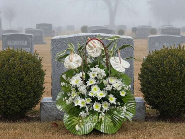Close-up of white anthurium and lily condolence arrangement