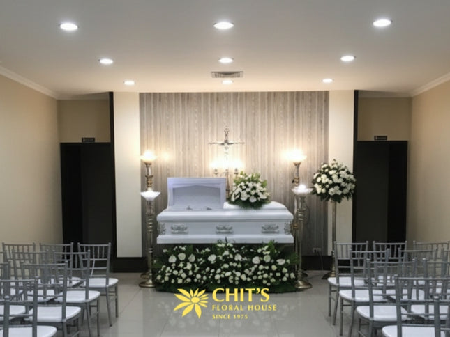 Elegant white casket flower arrangement featuring anthuriums and roses